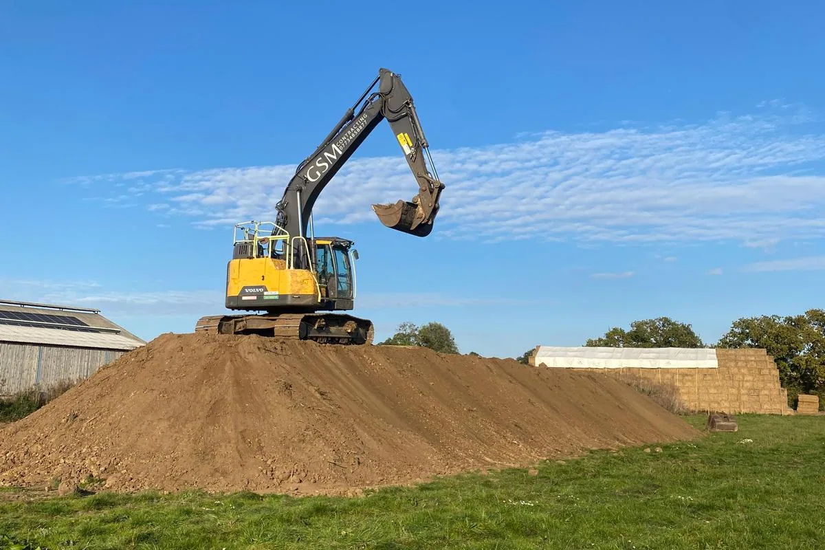 GSM Contracting excavator on a soil mound
